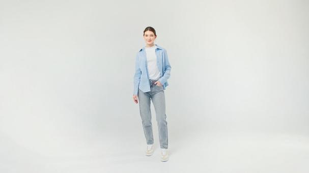 片手をポケットに入れる青シャツの女性 片手をポケットに入れる青シャツの女性の写真
