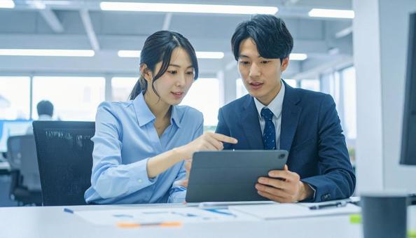 タブレットで打ち合わせするビジネス社員 タブレットで打ち合わせするビジネス社員の写真