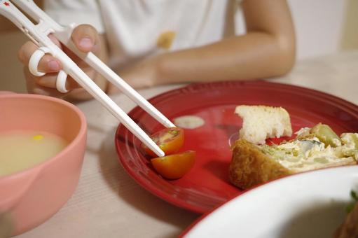 夕食をトレーニング箸で食べる子ども 夕食をトレーニング箸で食べる子どもの写真