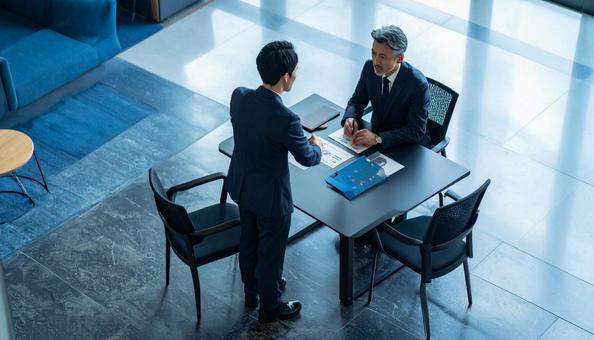 ビジネスラウンジで打合わせする2人の男性の写真