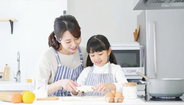 キッチンで楽しそうに料理をする母娘 キッチンで楽しそうに料理をする母娘の写真