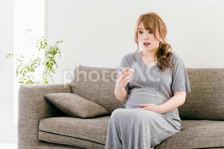 体温計を見て驚く妊婦の日本人女性 妊娠,妊婦,胎動の写真素材