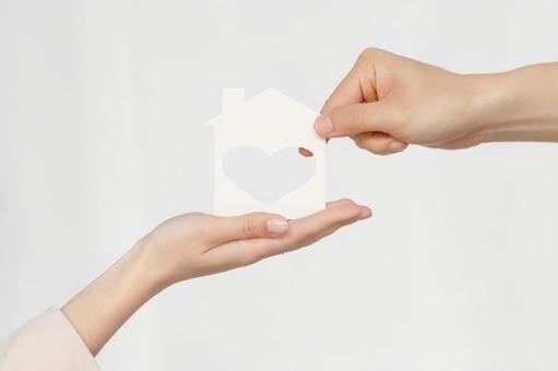 ハートに切り抜かれた家の紙を渡す 保険業,事務職,接客業の写真素材