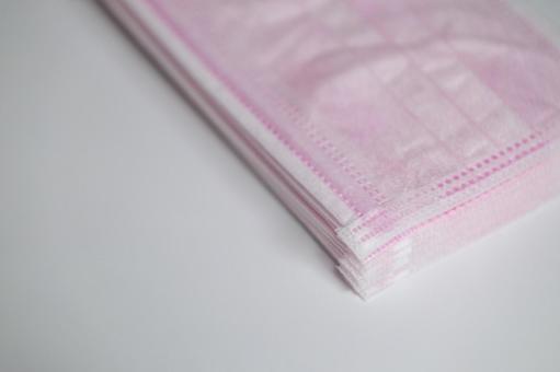 積み重ねられた淡いピンク色の不織布マスク 積み重ねられた淡いピンク色の不織布マスク マスク,不織布,サージカルマスクの写真素材