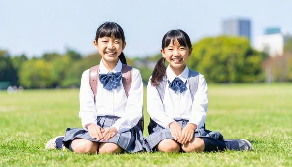 芝生に座って笑顔の日本人姉妹 芝生に座って笑顔の日本人姉妹の写真
