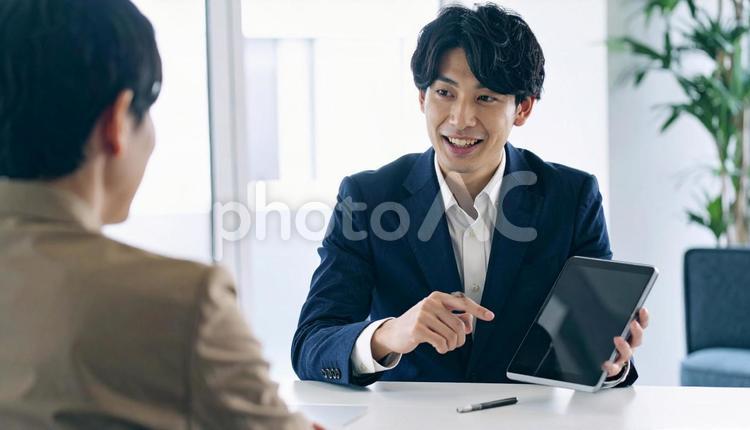 タブレットを使って説明する男性営業マン タブレット,男性営業マン,男性ビジネスマンの写真素材