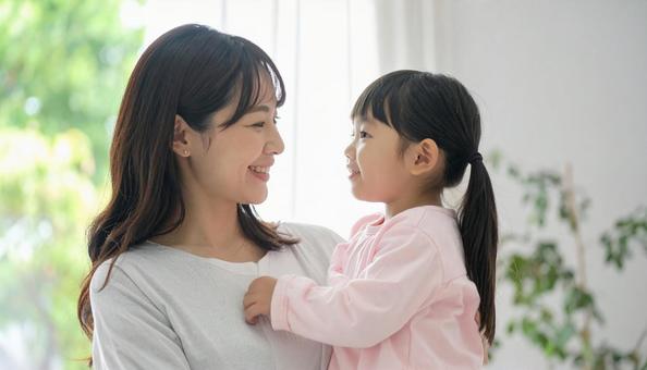 女の子を抱っこしてあやす母親 女の子を抱っこしてあやす母親の写真