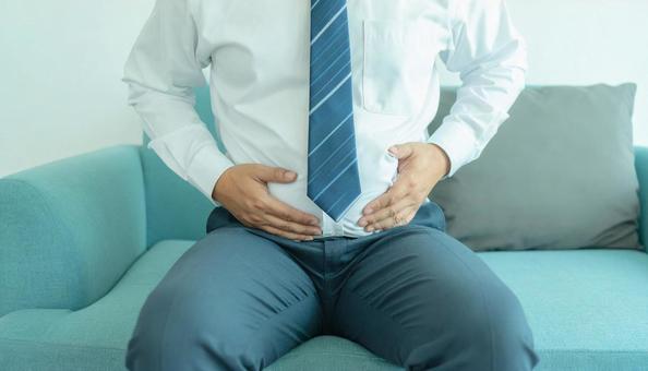 メタボリックなお腹に手を触れる男性 メタボリックなお腹に手を触れる男性の写真