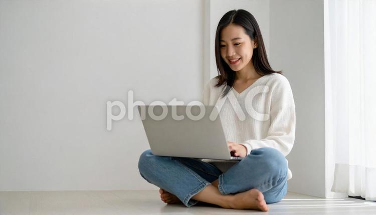 胡坐を組んでパソコン画面を見る女性 ノートパソコン,胡坐,女性の写真素材