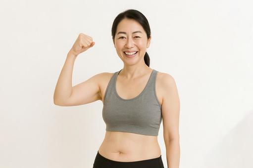 笑顔でガッツポーズをする中年女性 笑顔でガッツポーズをする中年女性の写真