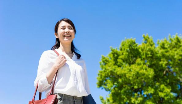 青空の自然の中を散歩する笑顔の日本人女性 青空の自然の中を散歩する笑顔の日本人女性の写真