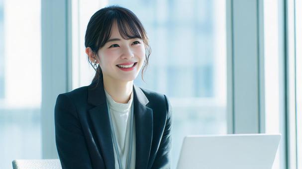 ノートパソコンを使用する女性会社員 ノートパソコンを使用する女性会社員の写真