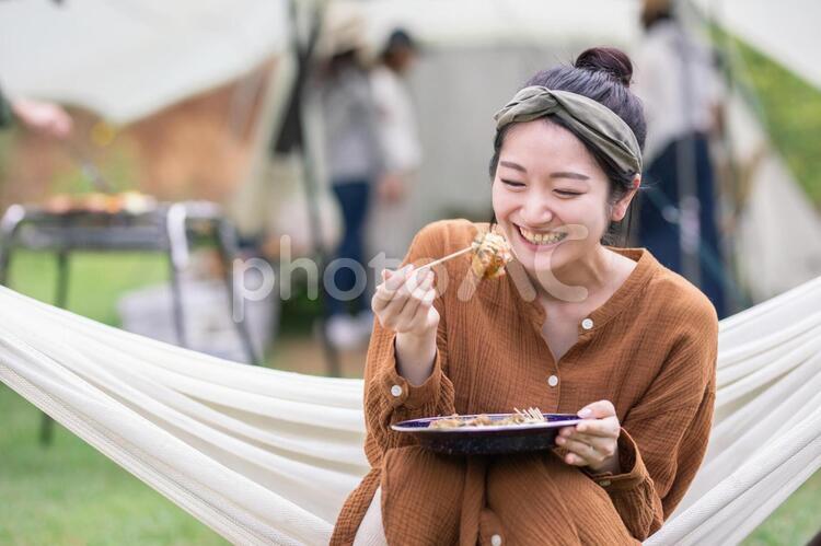 キャンプでたこ焼きを食べる女性 キャンプ,食べる,女性の写真素材