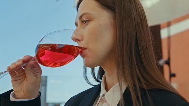 横向きで赤いドリンクを飲む女性 女性,外国人,ワインの写真素材