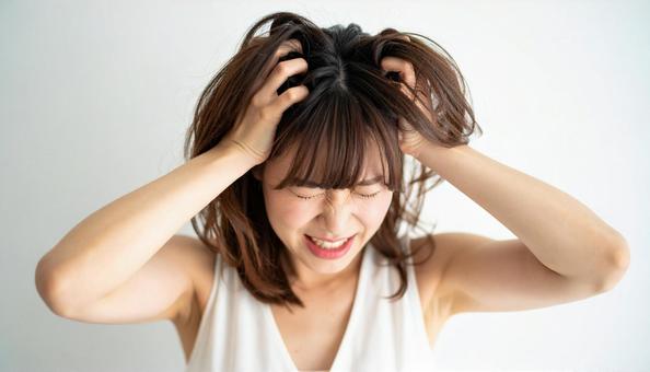 頭を抱えて困惑する若い女性の表情 頭を抱えて困惑する若い女性の表情の写真