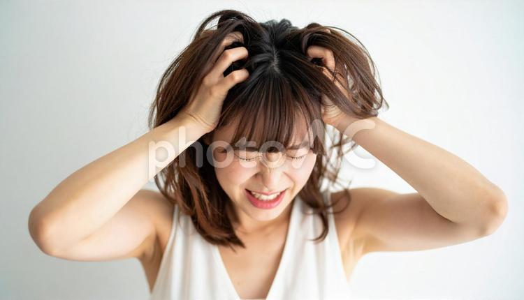 頭を抱えて困惑する若い女性の表情 人物,困惑,ネガティブの写真素材