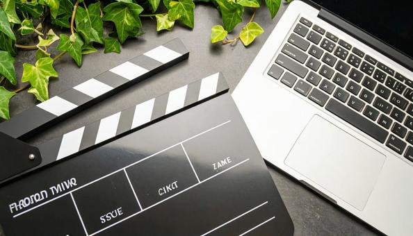 テーブルの上のカチンコとPC 動画製作費 テーブルの上のカチンコとPC 動画製作費の写真
