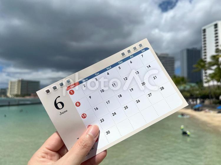 6月のカレンダーを持つ女性の手。2025 6月,カレンダー,卓上カレンダーの写真素材