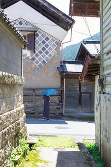 古い街並で日傘をさして佇む女性 古い街並で日傘をさして佇む女性 古い街並,蔵,小道の写真素材