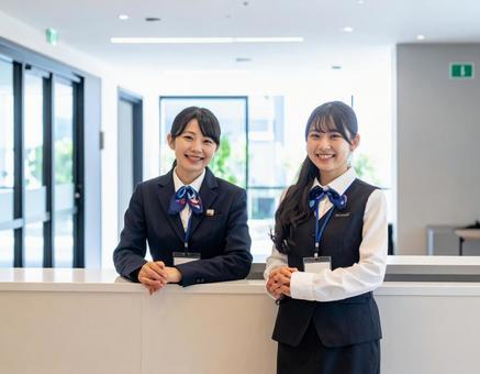 受付コーナー内に座る笑顔の受付嬢 受付コーナー内に座る笑顔の受付嬢の写真