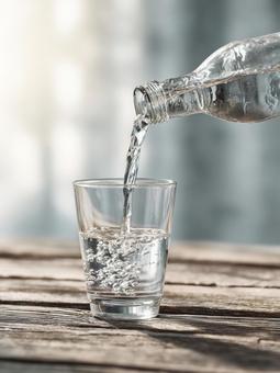 ペットボトルからコップへ水を注ぐ ペットボトルからコップへ水を注ぐの写真