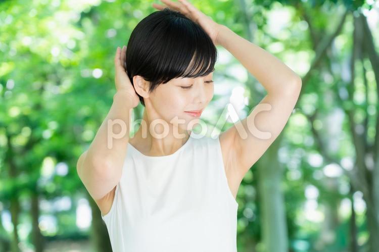 緑の中でヘアケアをする若い女性 ヘアケア,育毛,スキンケアの写真素材