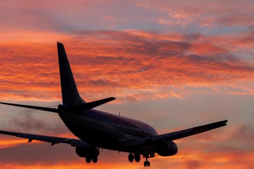 燃える夕焼け空と着陸する旅客機 燃える夕焼け空と着陸する旅客機の写真