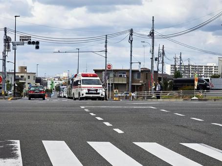 赤信号の交差点に進入する救急車 赤信号の交差点に進入する救急車 交差点,横断歩道,信号待ちの写真素材