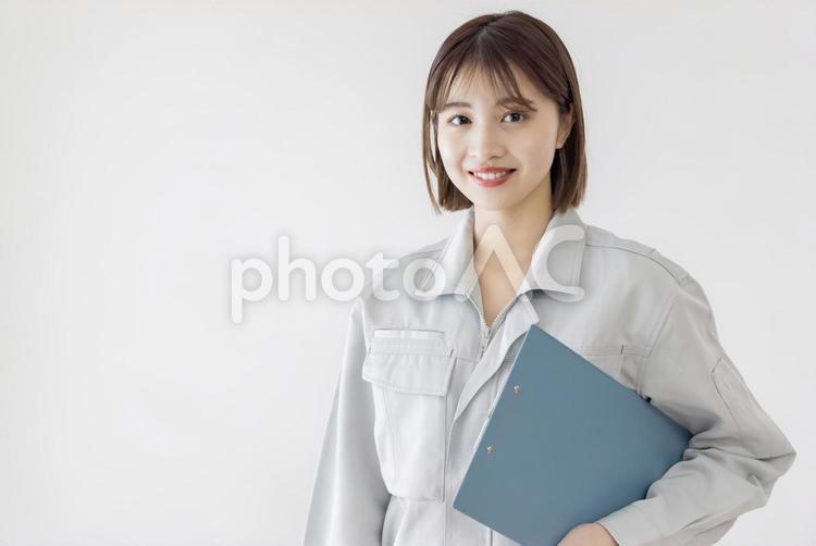 クリップボードを持つ作業服の女性　 女性,人物,日本人の写真素材