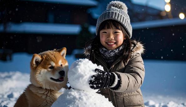 雪だるまを作る子供と犬 雪だるまを作る子供と犬の写真