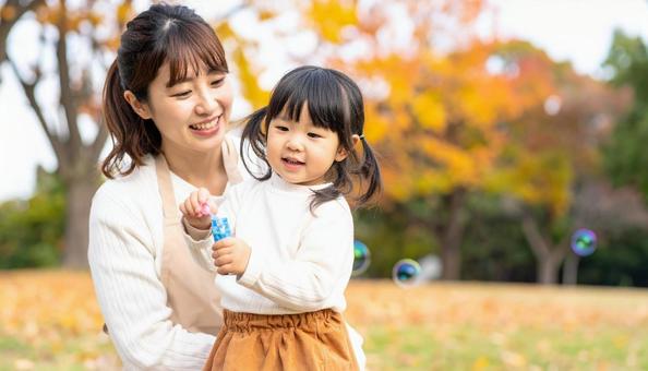 幼児教育 公園でシャボン玉で遊ぶ子と女性 幼児教育 公園でシャボン玉で遊ぶ子と女性の写真