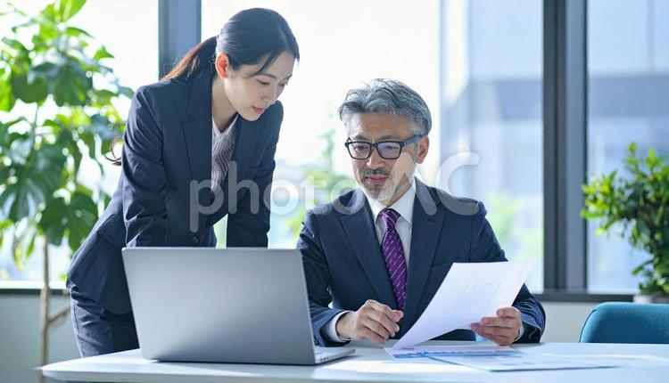 データを見ながら相談する上司と部下 ビジネスマン,ビジネスウーマン,男女の写真素材