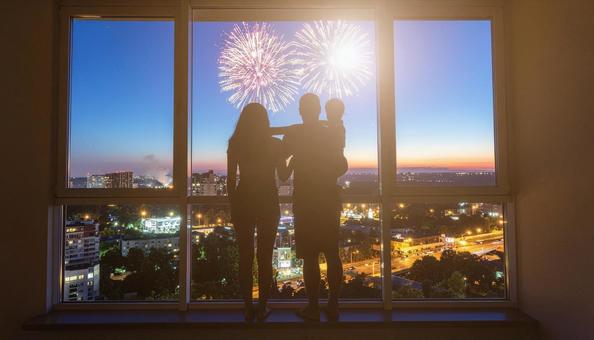 マンションの窓辺から打花火を見上げる家族 マンションの窓辺から打花火を見上げる家族の写真