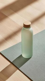 光と影に包まれたガラス製水筒とマット 光と影に包まれたガラス製水筒とマットの写真