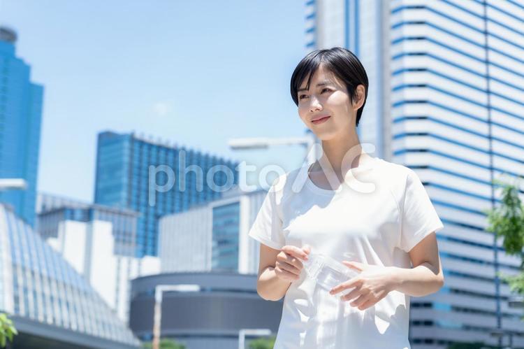 オフィス街をジョギングする若い女性 ランニング,ジョギング,フィットネスの写真素材