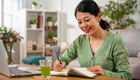 テキストを開きノートに書く日本人女性 テキストを開きノートに書く日本人女性の写真