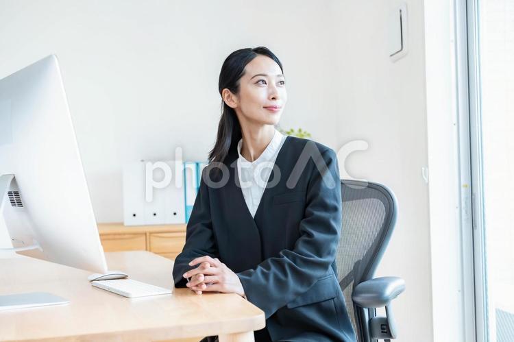 窓を見つめるスーツを着た女性 ビジネス,デスクワーク,女性の写真素材
