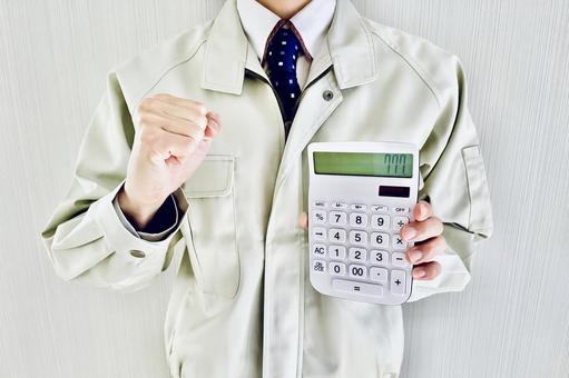 電卓を持ってガッツポーズする作業着の男性 作業員,人物,男性の写真素材