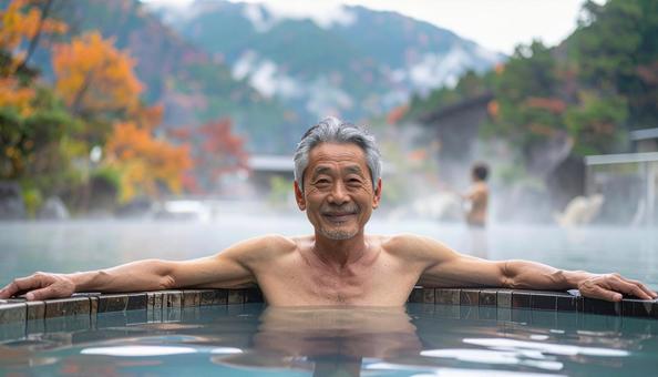 温泉につかってリラックスするシニア男性 温泉につかってリラックスするシニア男性の写真