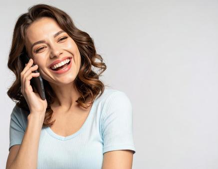 笑顔でスマホで話す女性 笑顔でスマホで話す女性の写真