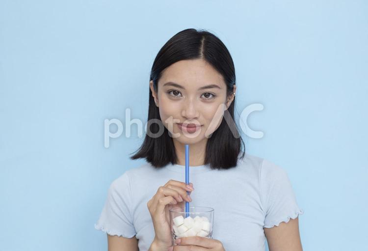 角砂糖のたくさん入った飲料を持っている女性2 女性,ブルー,カメラ目線の写真素材