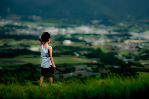 素材>高台から街を見下ろす旅行中の男の子 素材>高台から街を見下ろす旅行中の男の子の写真