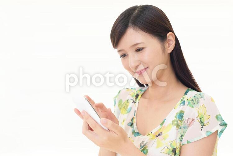スマートフォンを持つ笑顔の女性 女性,スマートフォン,女の写真素材