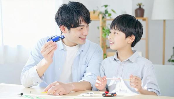 父親と一緒にプラモデルを作る男の子 父親と一緒にプラモデルを作る男の子の写真