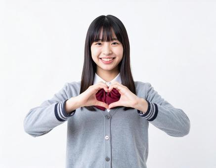 手でハートマークを作る女子生徒 手でハートマークを作る女子生徒の写真