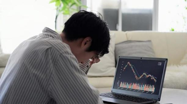 株価の下落を見て落ち込むアジア人男性 株価,下落,落ち込むの写真素材