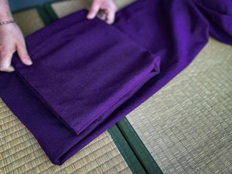 畳の上で丁寧に紫の着物を畳む手元の作業 畳の上で丁寧に紫の着物を畳む手元の作業 着物,畳む,和風の写真素材