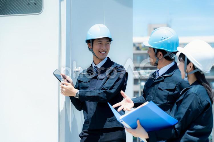 現場で働く作業員 作業服,打ち合わせ,ヘルメットの写真素材