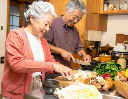 キッチンで会話しながら料理するシニア夫婦 キッチンで会話しながら料理するシニア夫婦の写真