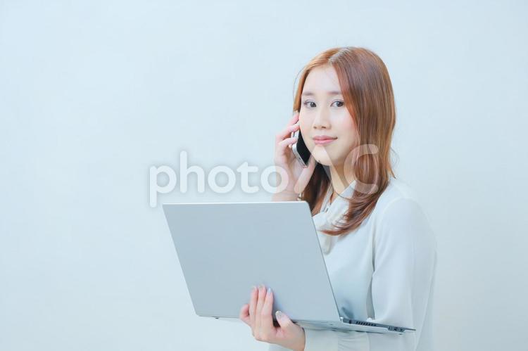 左手にPC右手にスマホのビジネスウーマン 女性,pc,olの写真素材